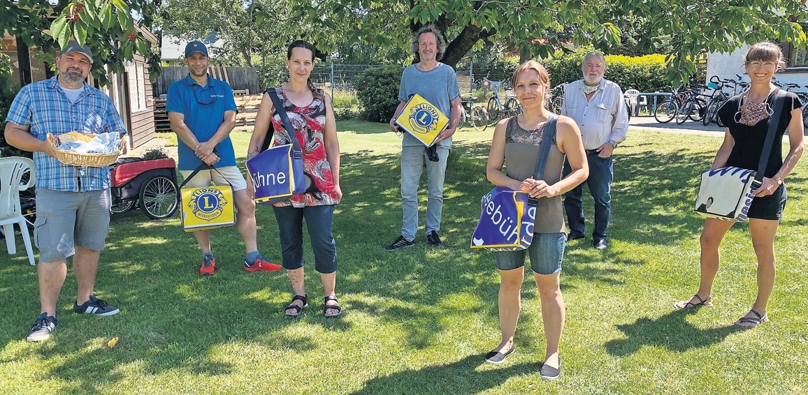 Ben Moske (von links), Lions-Präsident Thomas Kosch, Nicole Mohr, Tandem-Geschäftsführer Andreas von Glahn, Elea Himmert, Bernd Tetzlaff und Julia Lott-Hake bei der Übergabe der Spende an den Verein Tandem. Die aus Lkw-Plane und Konzertplakaten genähten Taschen mit Lions-Logo und anderen Motiven sind für 45 Euro pro Stück beim Tandem erhältlich. Ein waschbarer Mund-Nase-Schutz kostet fünf Euro.